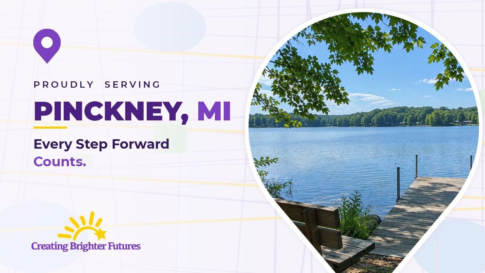 Map pin framing a wooden bench and dock at the edge of a calm, tree-lined lake, beside the words Proudly Serving Pinckney, MI and the Creating Brighter Futures logo.